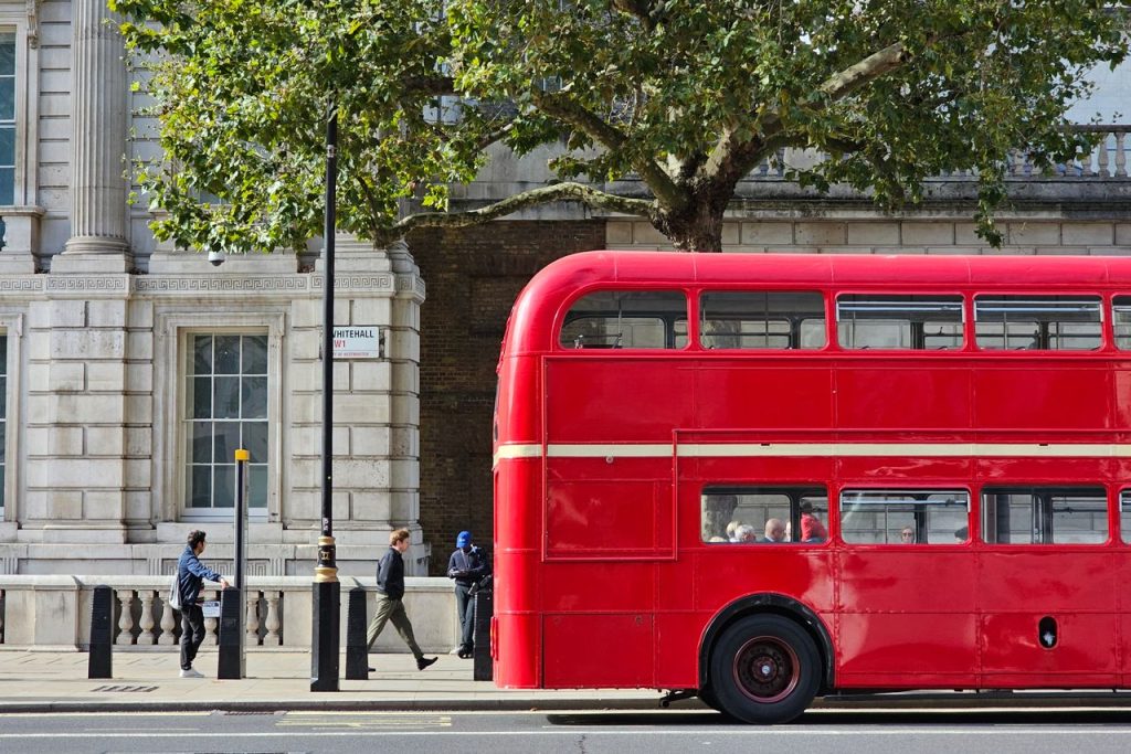 A red double-decker bus on a vibrant London street, capturing urban life.
